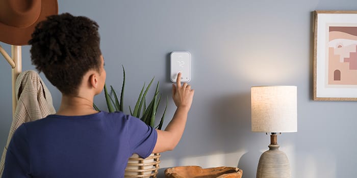 woman-adjusting-carrier-smart-thermostat-while-participating-in-carrier-smartsave