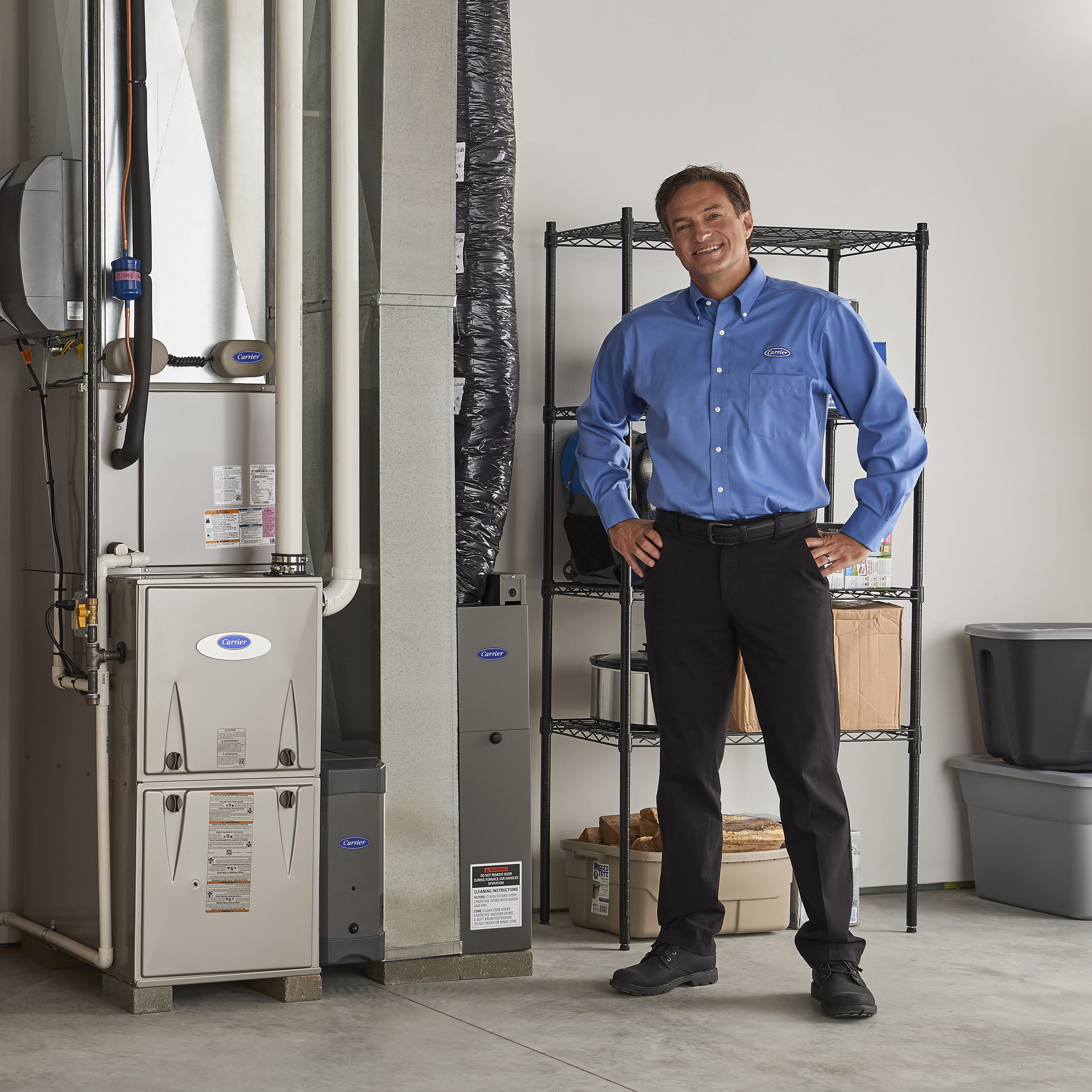 a carrier contractor stands next to a homeowner in a basement