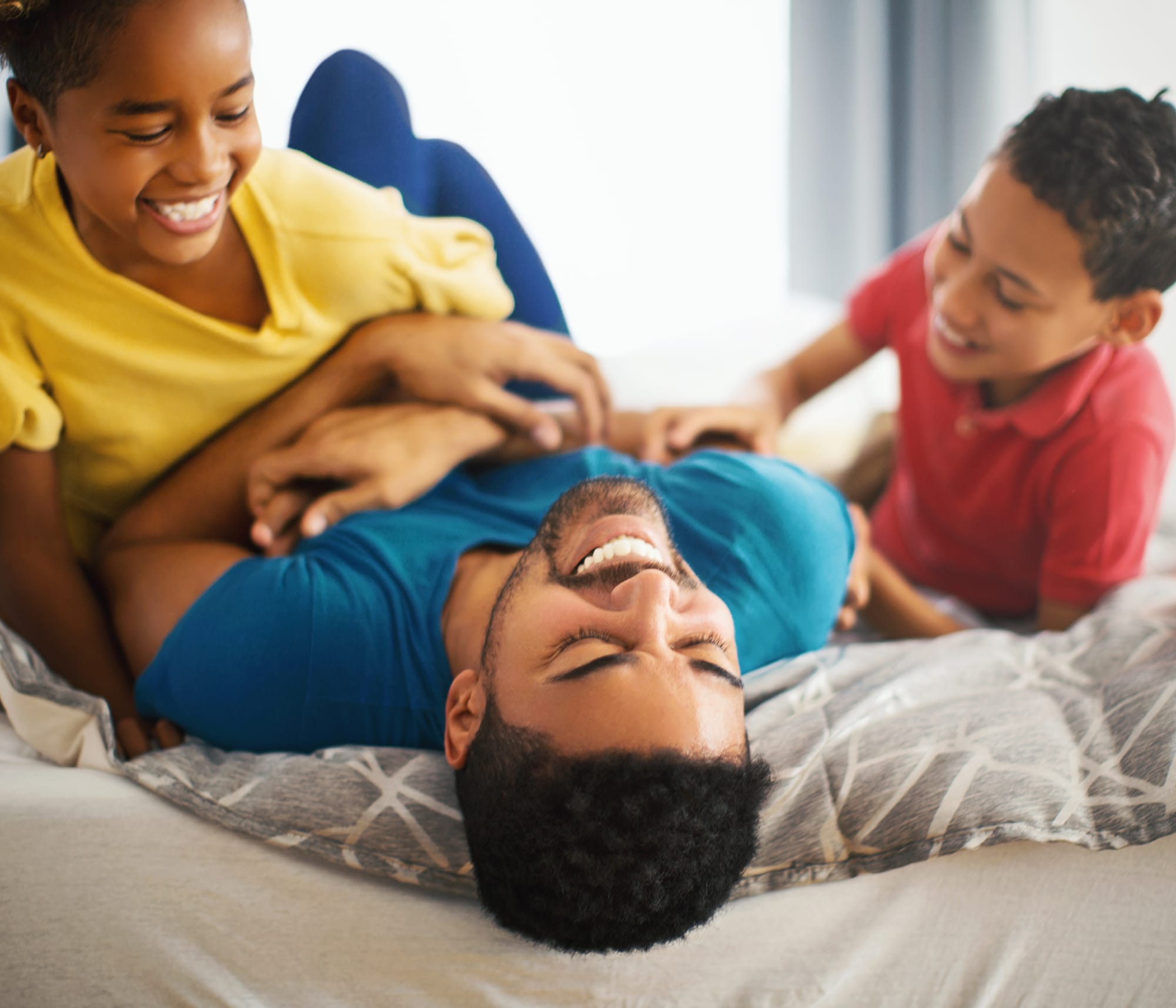 father with two kids on bed in home with indoor air quality products installed