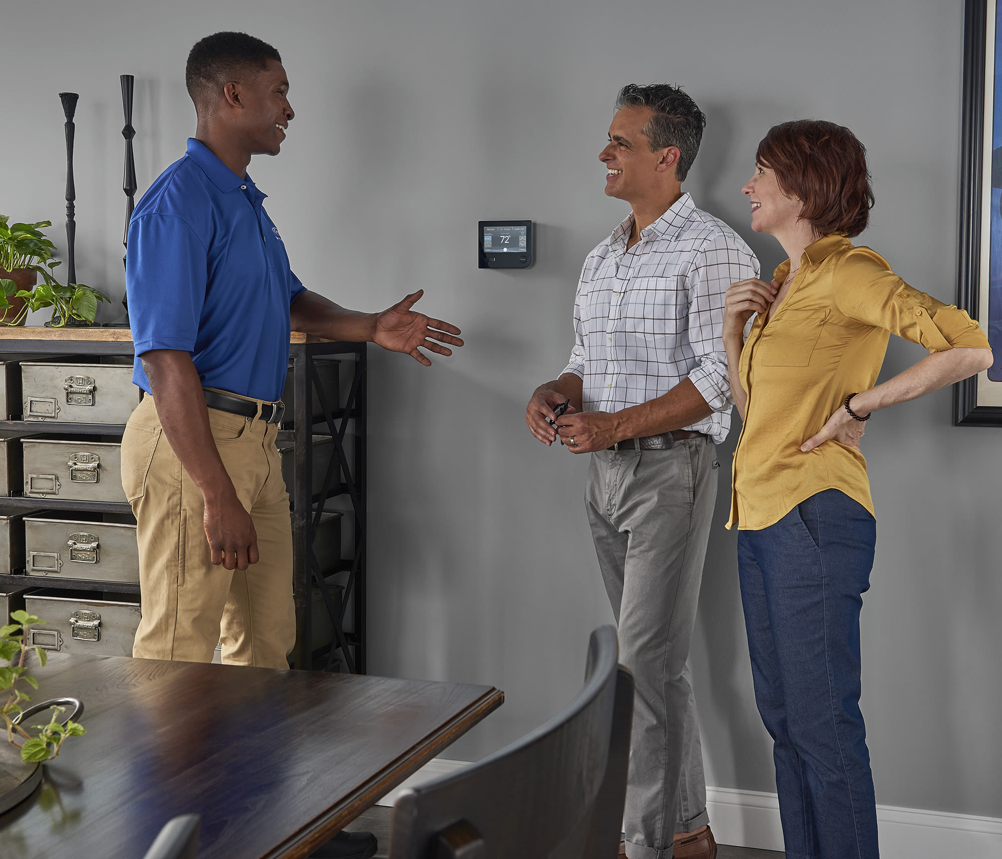 carrier dealer and a couple discuss smart thermostat and programmable thermostat options